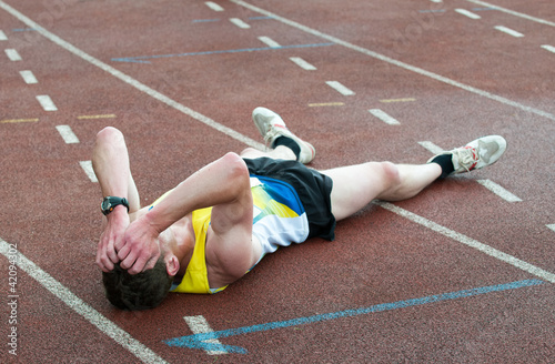 man lying on the ground at sport