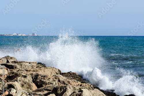 Sea waves breaks at rock coastline