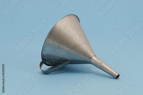Ancient metal aluminum funnel on blue background