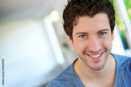 Portrait of cheerful young guy with blue eyes
