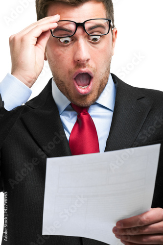 Shocked businessman while reading an expensive bill