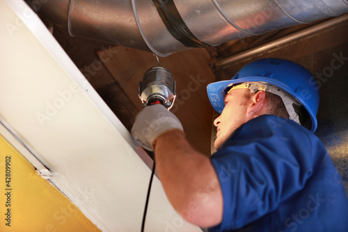 worker examining an attic