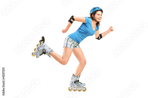 Full length portrait a smiling girl on rollers skating