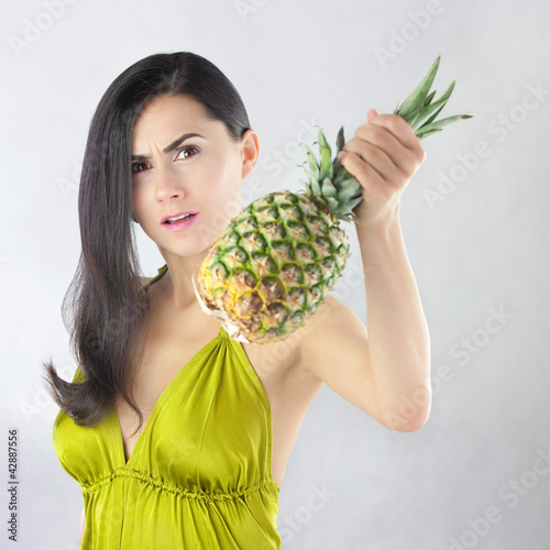 Zdenerwowana piękna kobieta z dojrzałym ananasem