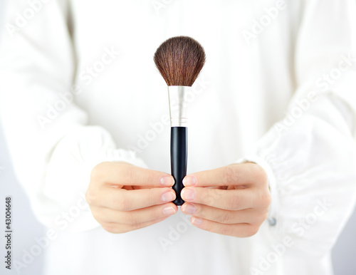 Kobieta trzymająca w dłoniach akcesoria do makijażu