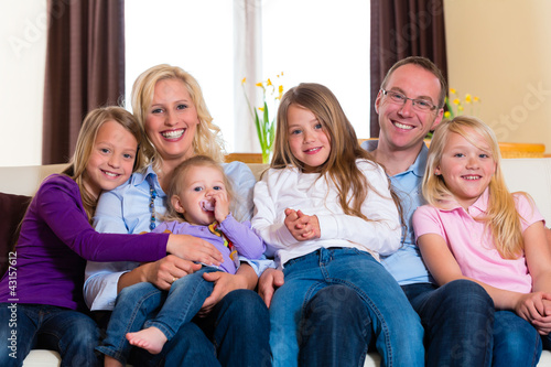 Familie auf der Couch daheim im Wohnzimmer