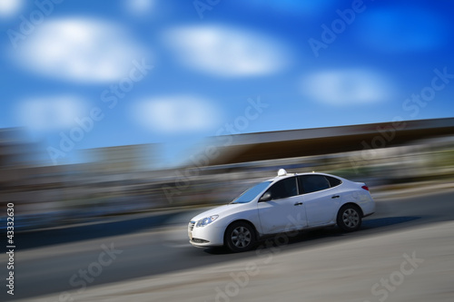 White car speeding with motion blur with blue sky