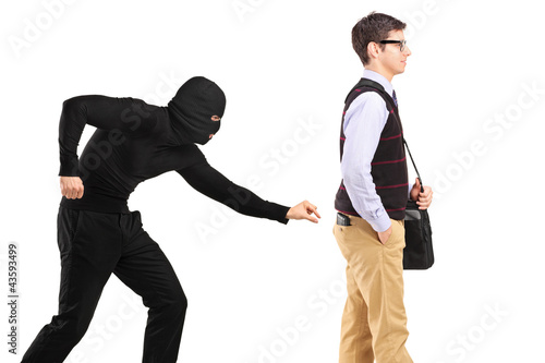 A pickpocket with mask trying to steal a wallet