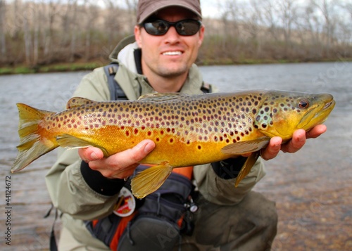 Fly fisherman holding a huge Brown Trout fish