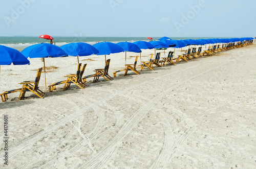 Beach lounge chairs with umbrellas.