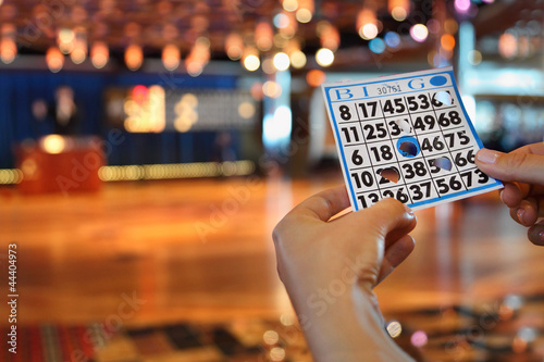 Hands hold bingo card with holes