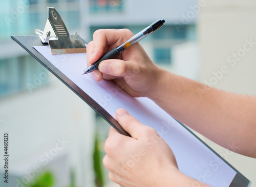 Businessman Holding A Clipboard And Writing