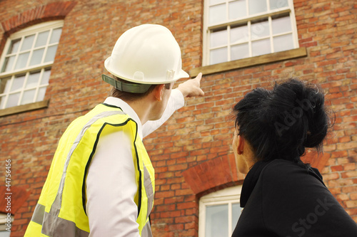 Surveyor or builder and homeowner looking at a property