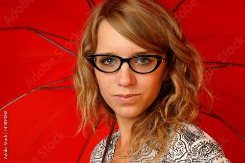 Girl in glasses with red umbrella