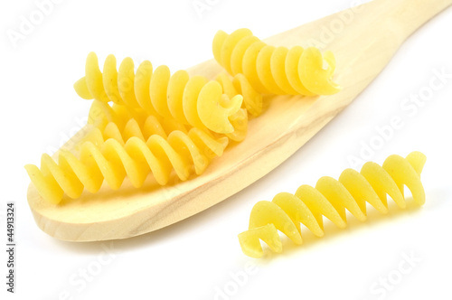 Uncooked fusilli in a wooden spoon, italian pasta