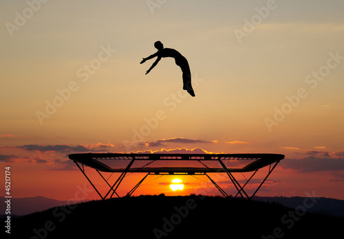 gymnast on trampoline in sunset