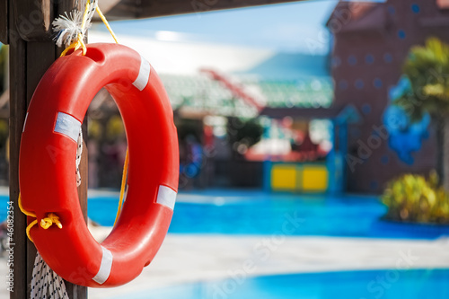 Lifebuoy hanging on a wooden beam at the pool