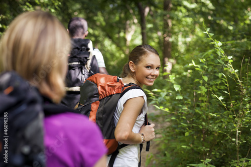 people with backpack doing trekking in wood