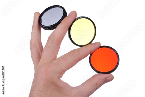 man hand holds three photographic filters, isolated on white