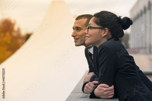 Couple of businessman and woman looking forward outdoors.