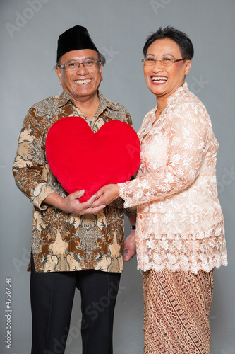 Senior indonesian couple in love. Traditional clothing. Studio.