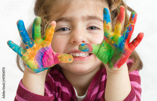 niña preescolar con las manos pintadas