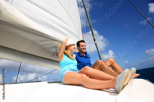Cheerful couple cruising on a catamaran in Caribbean sea