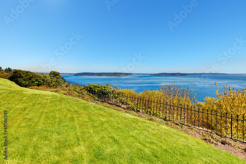 Water view and hill with grass. Private yard in Tacoma, WA.
