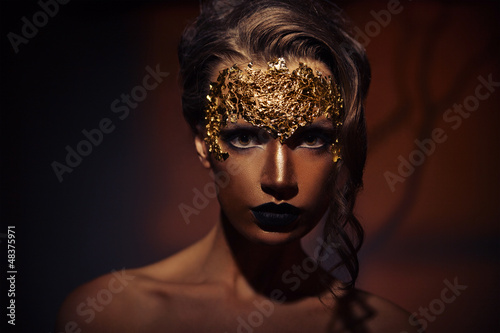 Woman with creative makeup against brown background