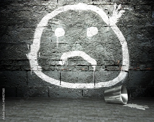 Graffiti wall with sad face, street background