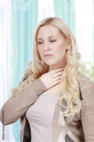 Hübsche Frau mit Schluckbeschwerden und Halsschmerzen