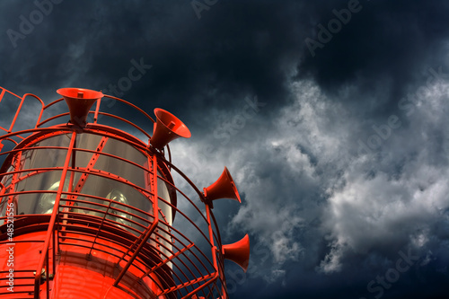 Red lightship with fog horns against storm clouds