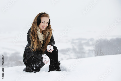 Piękna dziewczyna bawi się na śnieżnym zboczu góry