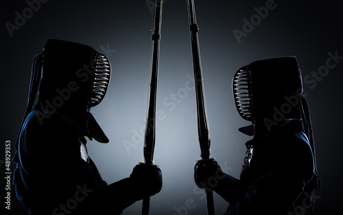 Two kendo fighters opposite each other with shinai