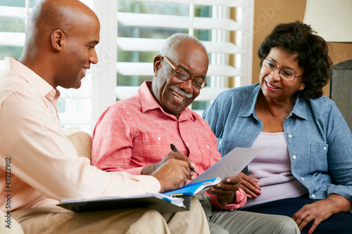 Financial Advisor Talking To Senior Couple At Home