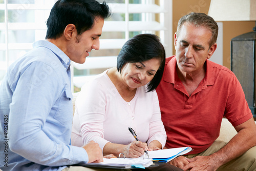 Financial Advisor Talking To Senior Couple At Home