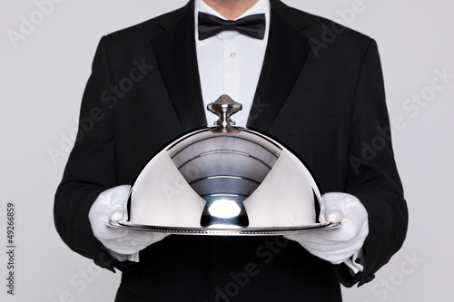 Waiter holding a silver cloche