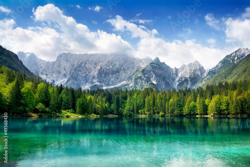 Türkisfarbener See mit Wald und Bergen