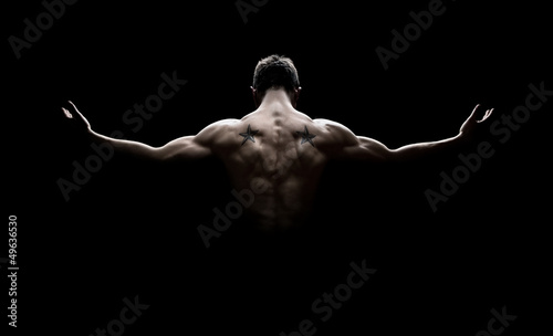 Rear view of healthy young man with arms stretched out