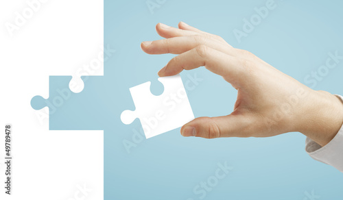 hand puts puzzle