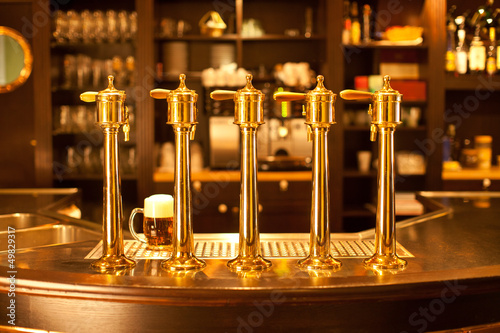 Luxury gold beer spigot at the brewery with a glass of beer