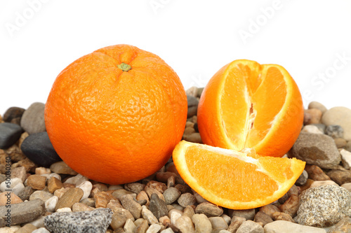 Pomarańcza w całości i pokrojona na kamieniach.