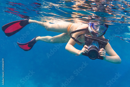 Young women snorkeling in the Andaman sea with underwater camera