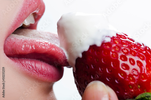 woman licks sour cream with strawberry