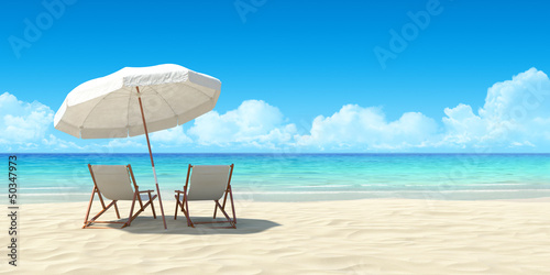 Chaise lounge and umbrella on sand beach.
