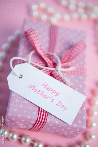 Pink gift wrapped box with mothers day greeting and pearls