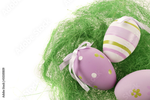 fioletowe jaja wielkanocne w koszyku na białym tle