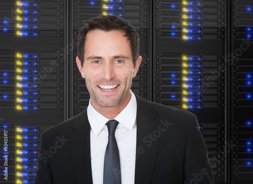 Businessman standing in front of server racks