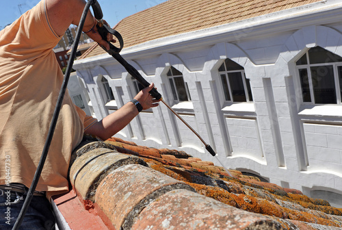 Trabajador limpiando un tejado