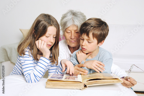 Kinder und Oma schauen ein Fotoalbum an